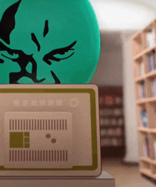 a green sphere with a face on it sits on top of a laptop