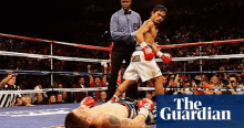 a boxer is laying on the ground in a boxing ring with the guardian newspaper in the corner