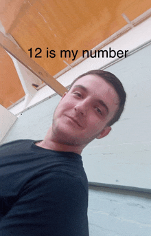 a man in a black shirt stands in front of a wooden ceiling and says 12 is my number