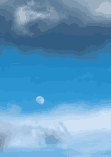 a blue sky with clouds and a full moon