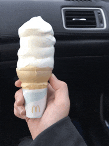 a person is holding a mcdonalds ice cream cone