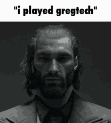 a man with a beard and long hair is wearing a suit and tie and says `` i played gregtech '' .