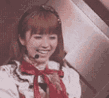 a woman is wearing a headset and a red bow tie .
