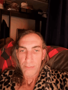 a man with long hair and a leopard print robe