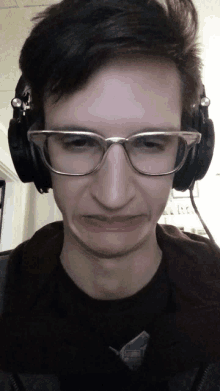 a man wearing glasses and headphones is making a face