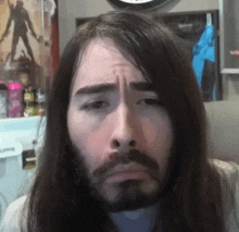 a man with long hair and a beard making a funny face