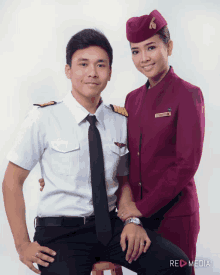 a man in a pilot uniform and a woman in a flight attendant uniform pose for a photo