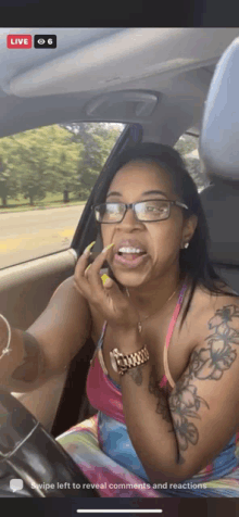 a woman wearing glasses is sitting in a car and making a funny face