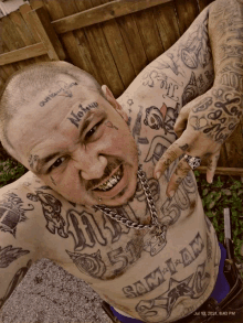 a shirtless man with a tattoo on his face that says no law