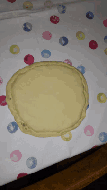 a circle of dough sits on a table with polka dots on it