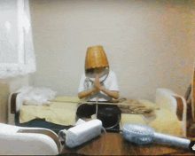 a person with a wicker hat on their head sitting in a bedroom