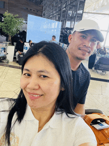 a man and woman are posing for a picture in an airport