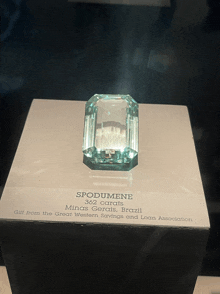 a display case with a large emerald cut emerald