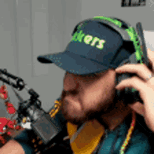 a man wearing a hat and headphones is talking on a phone .