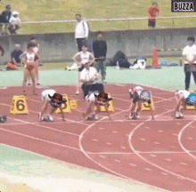 a group of people are getting ready to run on a track with buzza written on the bottom of the screen