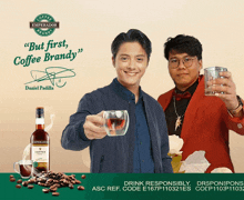 two men toasting with a bottle of coffee brandy behind them