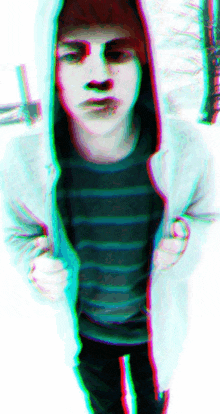 a man with red hair is wearing a hoodie and a striped shirt