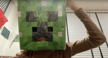 a person wearing a green minecraft creeper mask