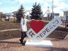 a woman stands in front of a sign that says i love perea 83