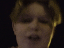 a close up of a person 's face with their eyes closed in the dark .