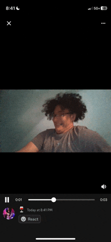 a video of a man with curly hair is being played on a cell phone