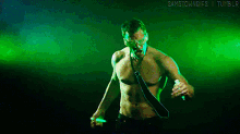 a shirtless man in a tie is dancing in front of a green background that says samstowngifs