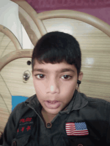 a young boy wearing a jacket with an american flag patch on his chest