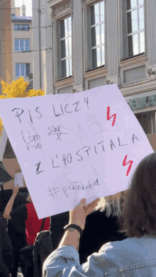 a person holds up a sign that says pis liczy