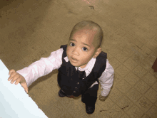 a young boy wearing a suit and tie looks up at the camera