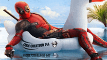 a man in a deadpool costume is laying on an inflatable swan in a pool