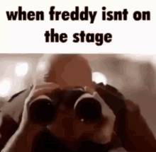 a man is looking through binoculars with the words `` when freddy isnt on the stage '' above him .