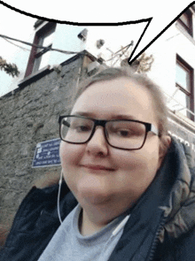 a woman wearing glasses and headphones stands in front of a building with a sign that says no parking