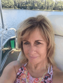 a woman is sitting on a boat in front of a lake