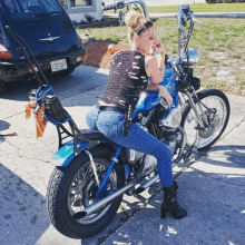 a woman sitting on a harley davidson motorcycle with a license plate that says gsc-493