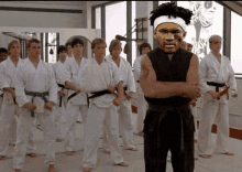 a man with a bandage on his head is standing in front of a group of karate players