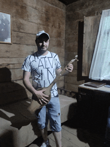 a man in a calvin klein t-shirt holds a guitar