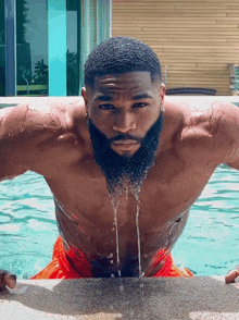 a shirtless man with a beard is in a pool of water