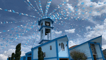 a blue building with a clock tower and blue flags