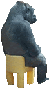 a gorilla figurine is sitting on a yellow chair .