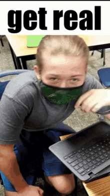 a girl wearing a green bandana is sitting at a desk with a laptop and the words get real behind her