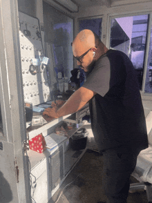 a man in a black shirt is standing in front of a counter with keys on it