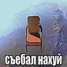 a chair is sitting on the ground in front of a mountain with a foreign language written on it .