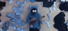 a person wearing a blue hoodie with a mask on laying on the floor