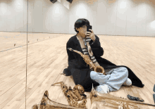 a man is sitting on the floor playing a saxophone