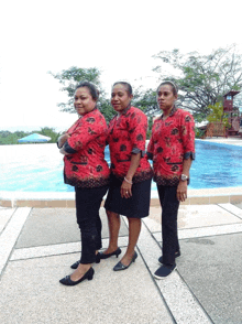 three women standing next to each other wearing red shirts