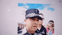 a man in a police uniform stands in front of a crowd