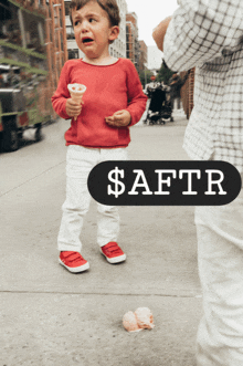 a little boy is crying while holding an ice cream cone and a sign that says $ aftr