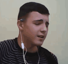 a young man is wearing headphones and singing into them .