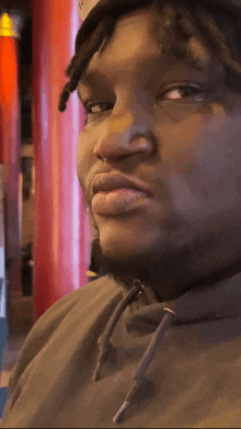 a close up of a man 's face with a hoodie and a hat on