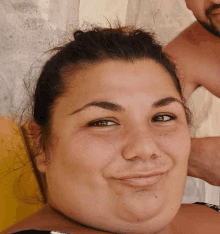 a close up of a woman 's face with a smile